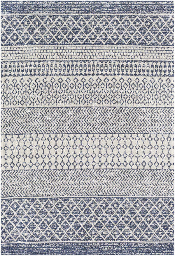 Close-up of the Flockton Washable Area Rug. Light blue, navy, and white geometric patterns create a bohemian style. Design-Rectangle-5373