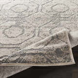 Close-up of the Frenchtown Area Rug, a clearance item with a gray and beige floral pattern and textured design. Fold