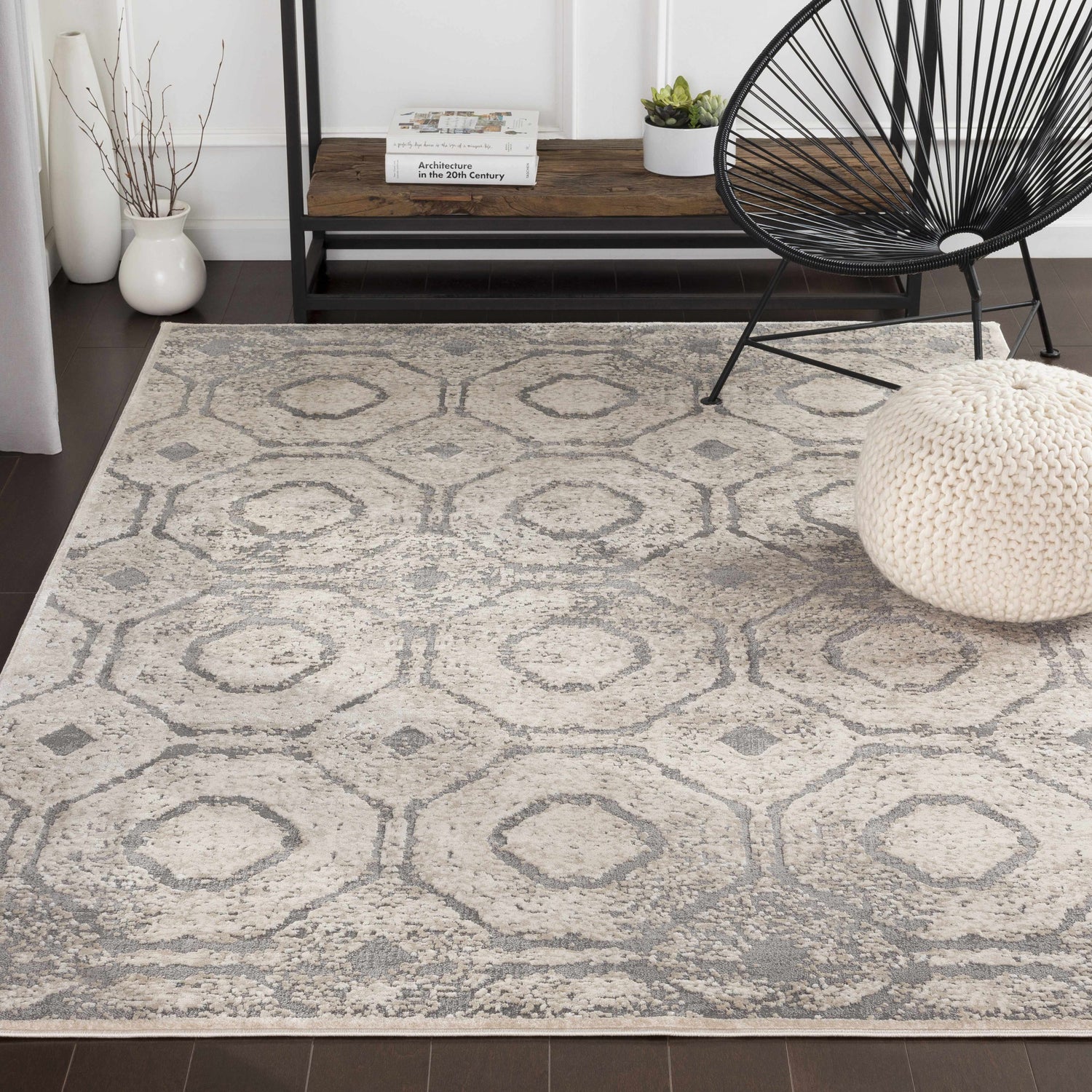 Living room scene with a Frenchtown Area Rug in gray and cream, black chair, and white pouf. Roomscene-Rectangle