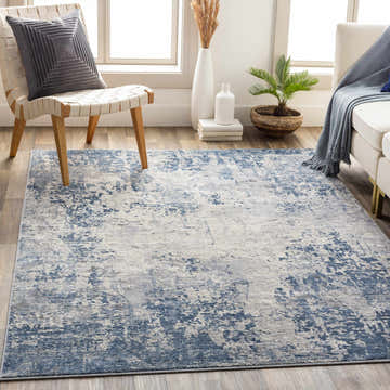Living room scene with a blue and gray Fruitland Area Rug, white sofa, and modern chair. Roomscene-Rectangle