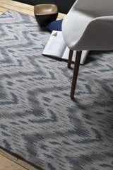 Close-up of the Fryeburg Area Rug showing beige, gray, and lavender abstract pattern and hand woven texture. Styleshot