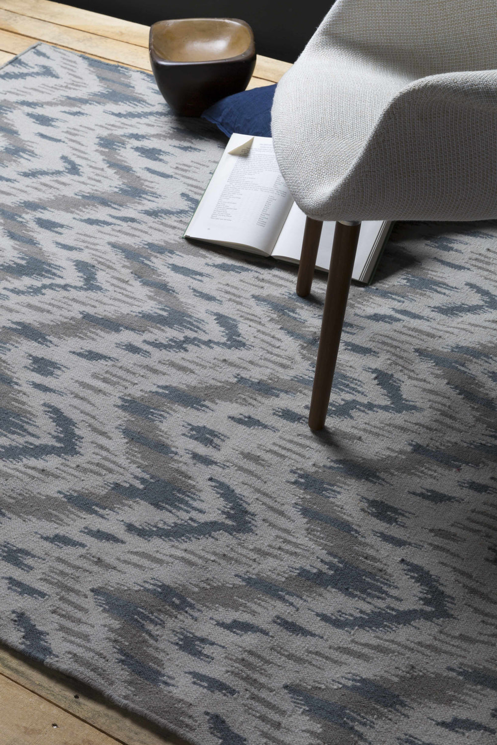 Close-up of the Fryeburg Area Rug showing beige, gray, and lavender abstract pattern and hand woven texture. Styleshot