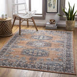 Living room scene with a beige and blue Fullarton Performance Rug, white chair, and natural wood accents. Roomscene-Rectangle