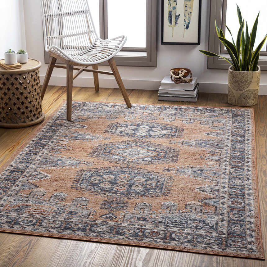 Living room scene with a beige and blue Fullarton Performance Rug, white chair, and natural wood accents. Roomscene-Rectangle