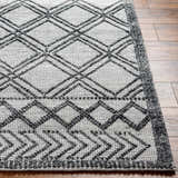 Close-up of the Gada Area Rug, showing its dark gray geometric pattern and hand-woven texture on a light gray base. Front