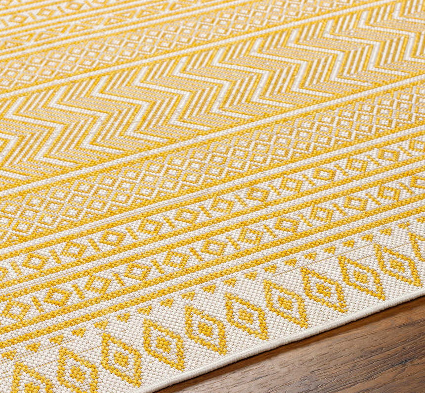 Close-up of the Galal Area Rug, a machine-woven rug with a geometric pattern in beige and yellow. Farmhouse style. Texture