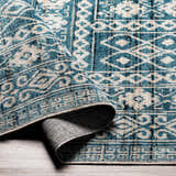 Close up of Gandy Washable Area Rug in blue and cream, showing geometric pattern and texture. Fold