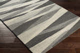 Close-up of Garlands Area Rug. Hand-tufted 100% wool rug with a contemporary black, charcoal, and gray geometric pattern. Corner