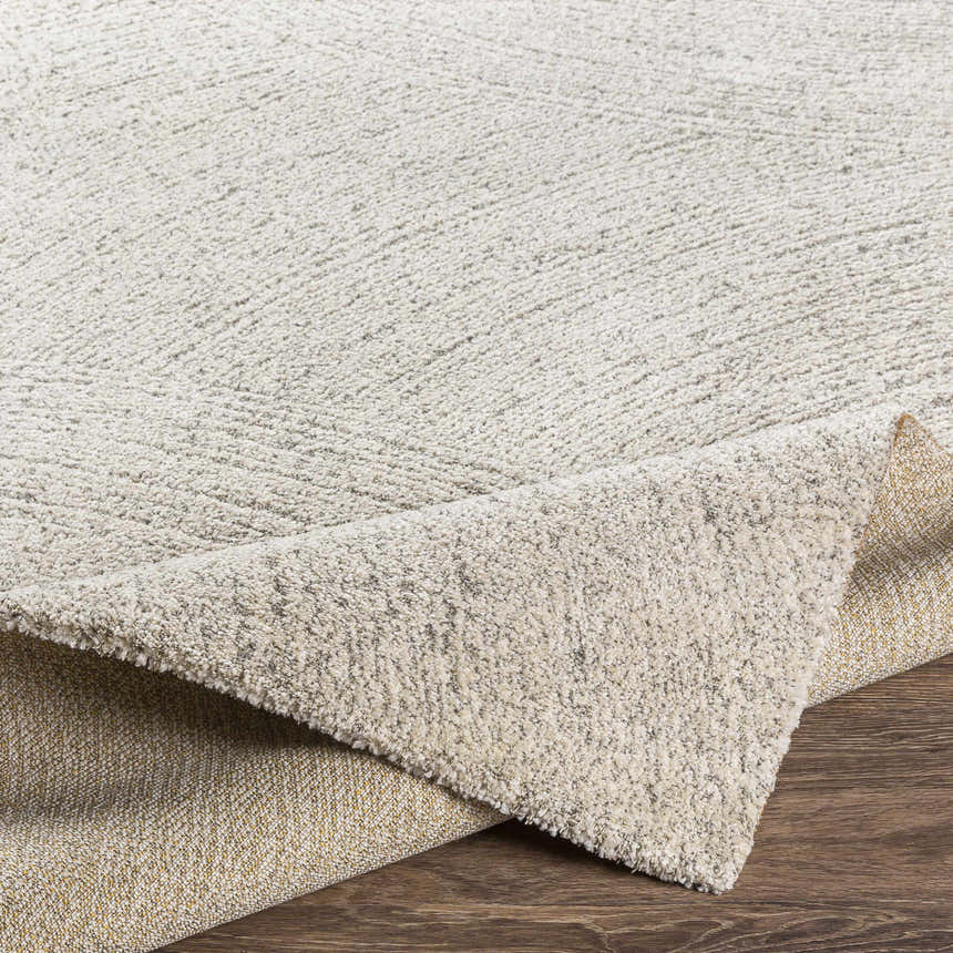Close-up of the Eaglehawk Luxe Rug showing its cream and charcoal textured design and durable backing. Fold