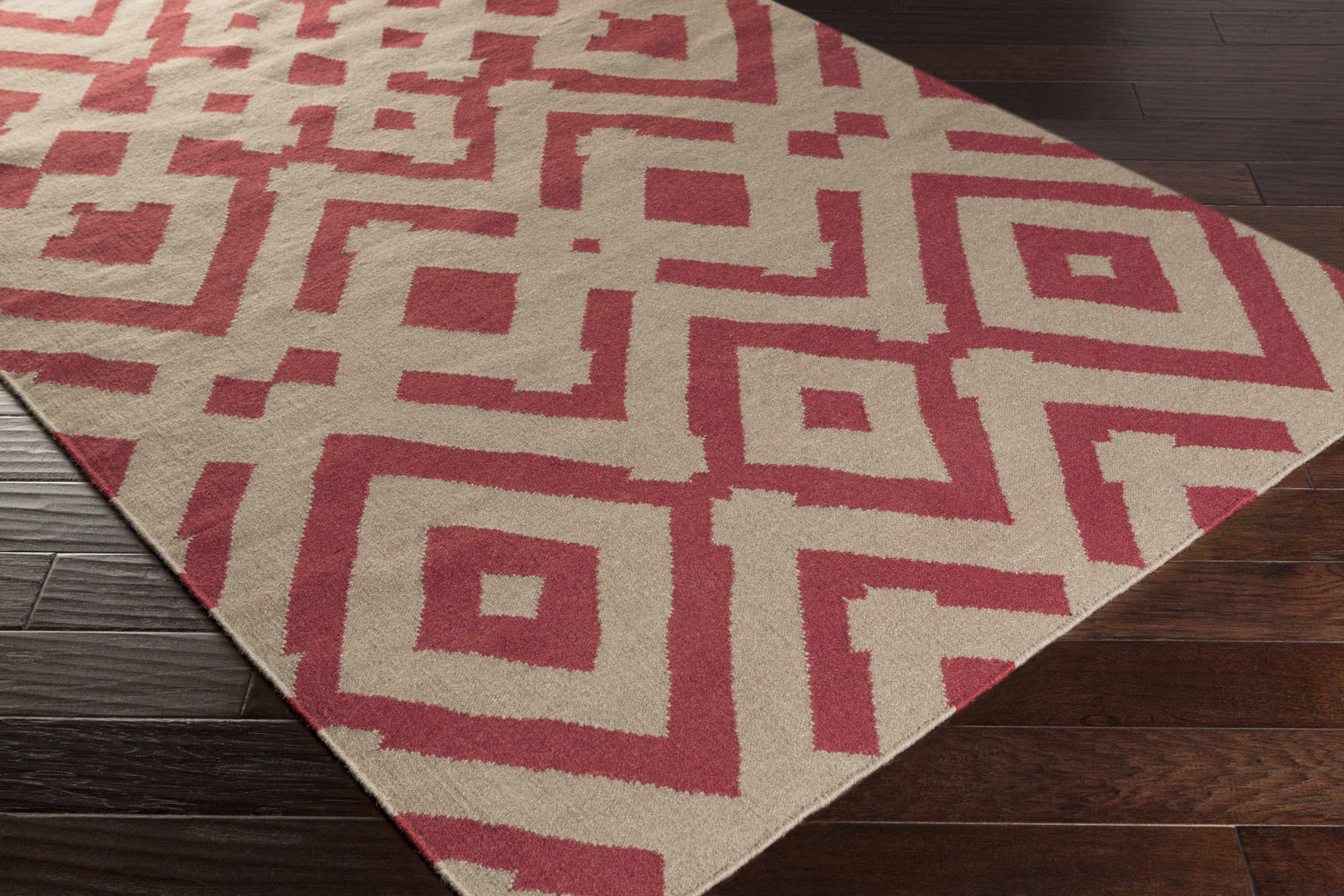 Close-up of the Goldsboro Area Carpet, a hand-woven wool rug in burgundy and taupe with a contemporary geometric pattern. Corner