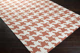 Close-up of the Goldthwaite Area Rug: burnt orange and light beige houndstooth pattern, hand woven wool texture. Corner