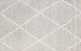 Close-up of the Gonvick Area Rug. Light gray rug with a raised off white diamond pattern. Hand knotted viscose texture. Swatch