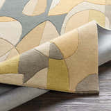 Close-up of the hand-tufted Grampian Area Rug showing the olive, sage, slate blue, and tan geometric pattern. Fold