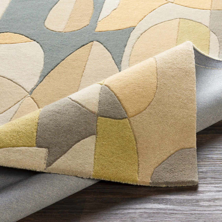 Close-up of the hand-tufted Grampian Area Rug showing the olive, sage, slate blue, and tan geometric pattern. Fold