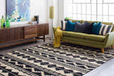 Living room scene with a black and gray geometric Gratiot Area Rug, green sofa, and mid-century modern furniture. Roomscene-Rectangle