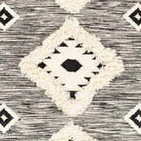 Close-up of the Gardner Cream on Gray Wool Tassel Rug, featuring a geometric diamond pattern and tasseled texture. Swatch
