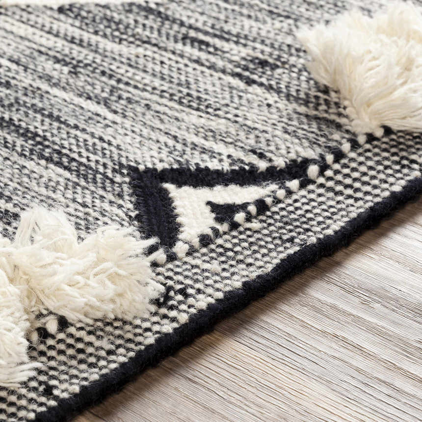 Close-up of the hand woven Gardner Cream on Gray Wool Tassel Rug, showing the texture and tassel detail. Texture