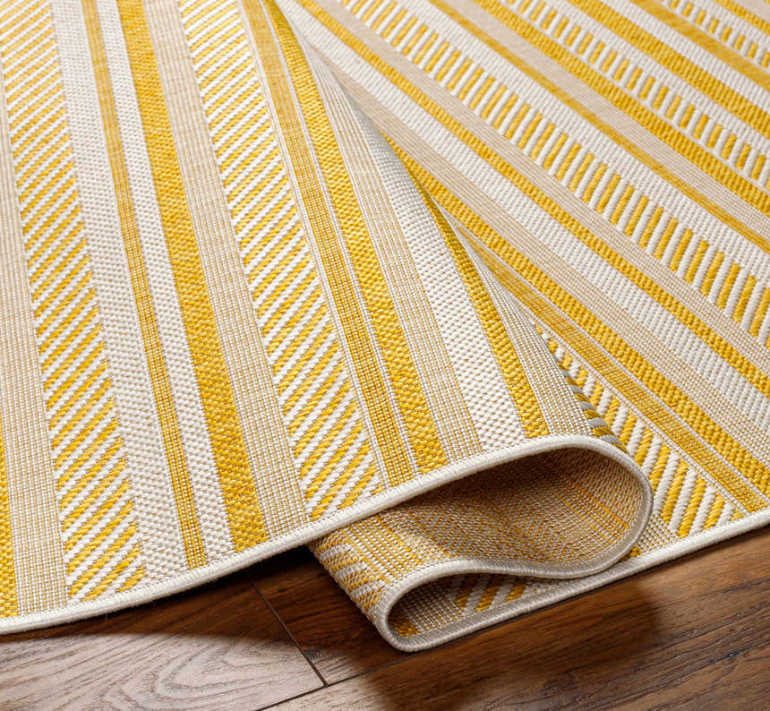 Close-up of the Grian Area Rug. Features a striped pattern in beige, bone, and metallic gold. Machine woven texture. Fold