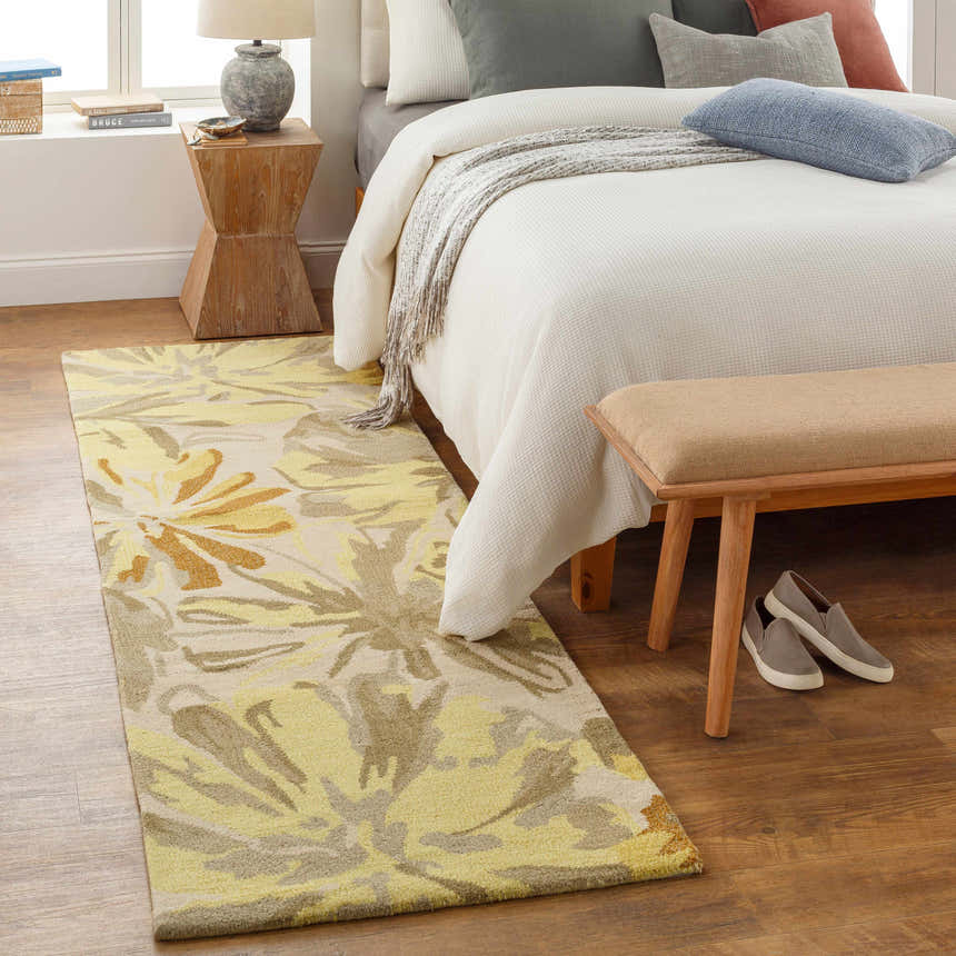 Bedroom scene with a Grindstone Area Rug in light gray, olive, and tan floral pattern on wood floor. Bed with bench. Roomscene-Runner