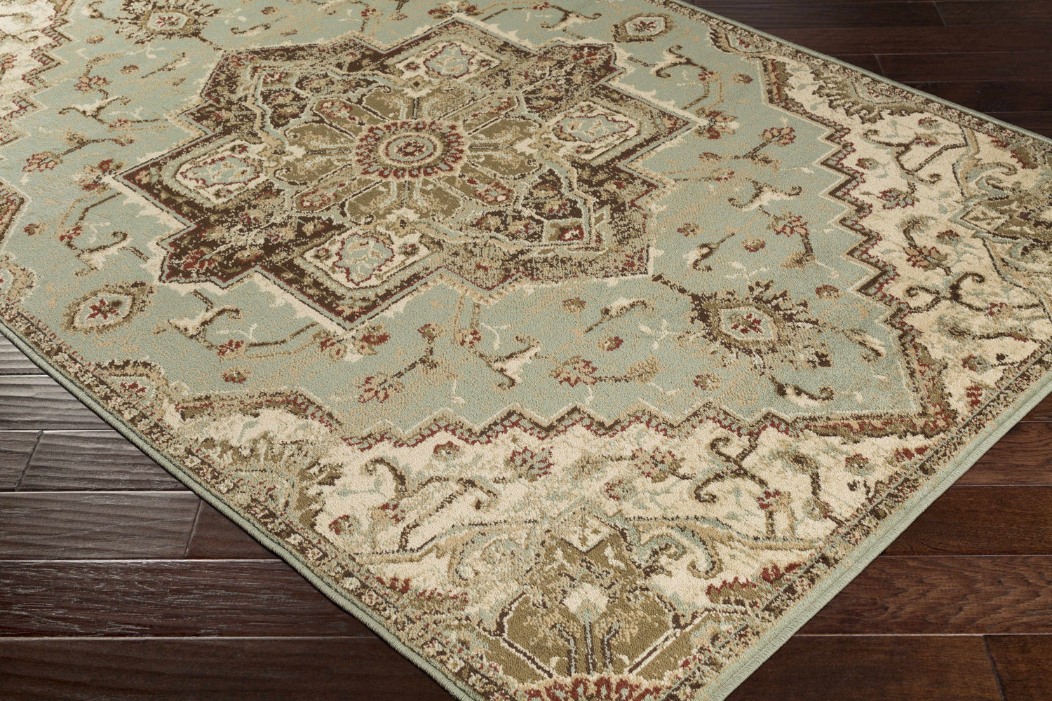 Close-up of the Granger Area Rug featuring a traditional oriental design in sage, beige, brown, and burgundy. Corner