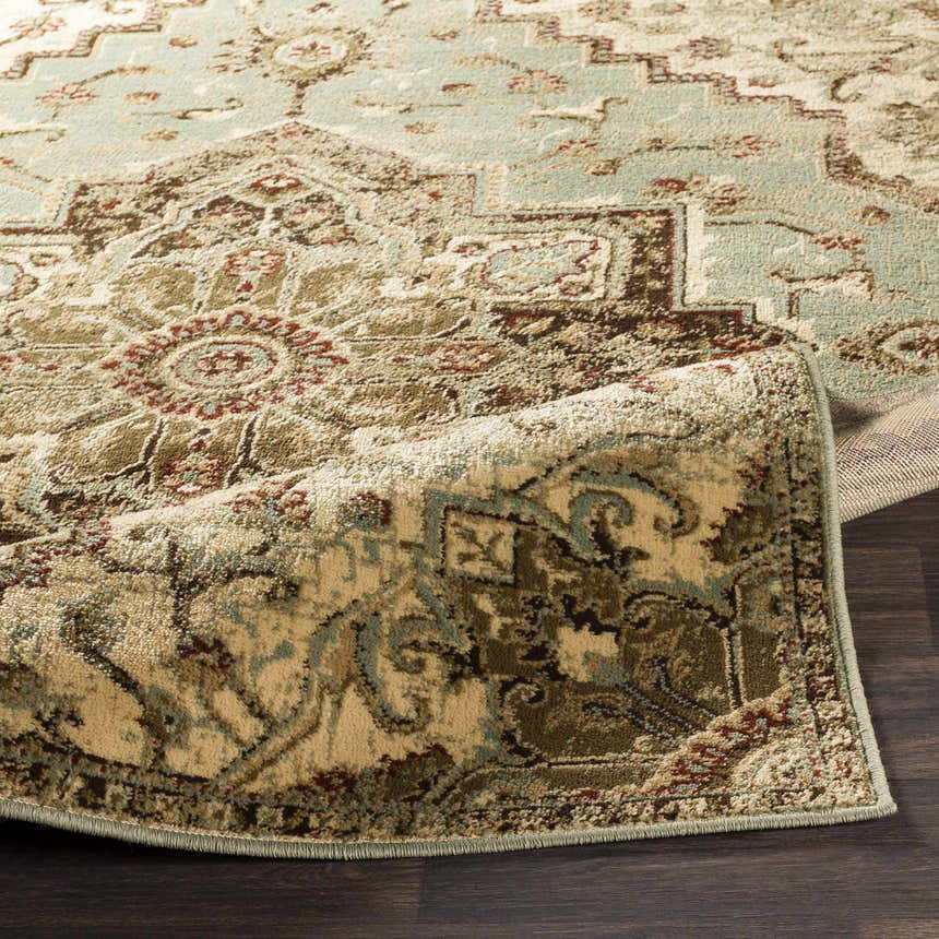 Close-up of the Granger Area Rug, a traditional design in burgundy, beige, sage, and brown tones. Fold