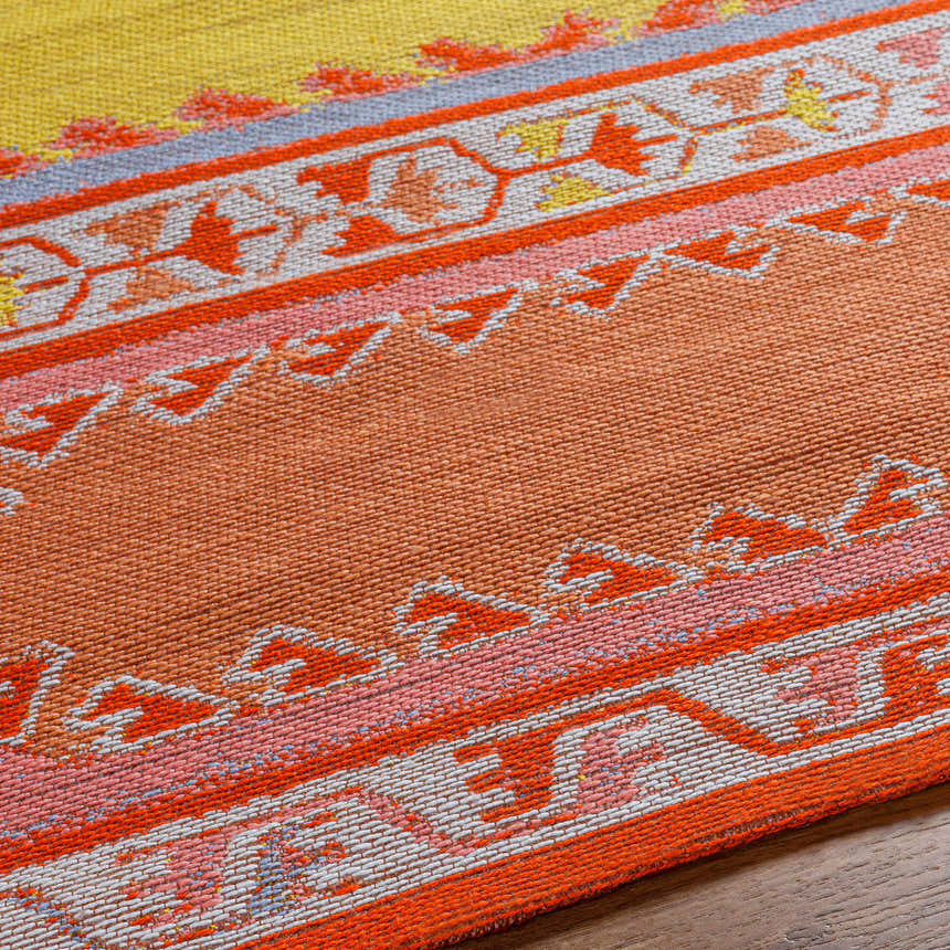 Close-up of the hand woven Gumberry Area Rug. Brick red, mustard, and pink Southwestern pattern. Recycled PET yarn texture. Texture