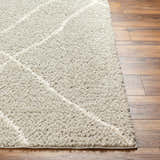 Close up of the Hadas Area Rug showing the shag texture and geometric pattern on wood floors. Front