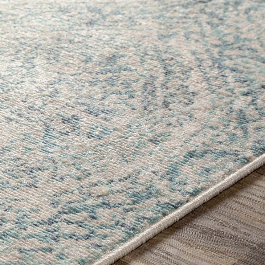 Close-up of the Halbur Area Rug showing its aqua, beige, and blue speckled design and soft texture. Texture