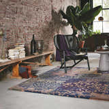 Loft room scene with brick wall, Hallsboro Area Rug in charcoal, brown, gray tones, chair, and books. Roomscene-Rectangle