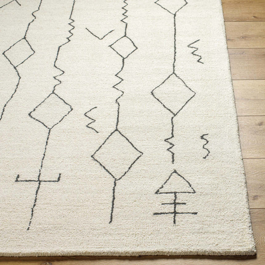 Close up of the Hanny Area Rug, a beige wool rug with a black geometric pattern. Front