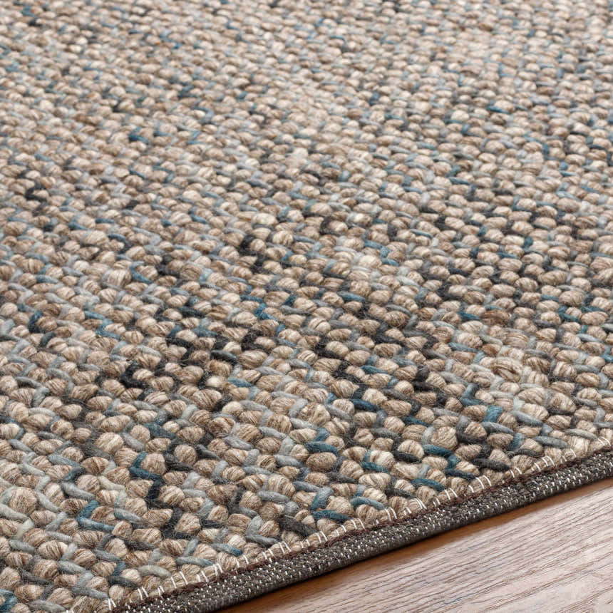 Close-up of the hand woven Hansell Area Rug. Charcoal, ice blue, and ivory wool rug texture. Texture