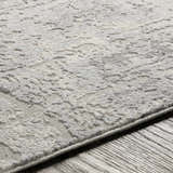 Close-up of the textured, abstract pattern of the Hardeeville Area Rug in shades of white and gray. Texture
