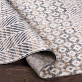 Close-up of the Hassocks Area Rug showing charcoal, cream, tan diamond pattern and backing on dark wood floor. Clearance rug. Fold