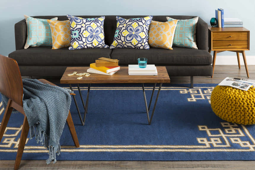 Living room scene with dark blue Hinckley Area Rug, gray sofa, wood furniture, and colorful pillows. Roomscene-Rectangle