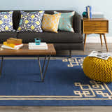 Living room scene with dark blue Hinckley Area Rug, gray sofa, wood coffee table and yellow pouf. Roomscene-Rectangle