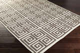 Close-up of the Hollytree Area Rug. Cream and dark red PVC rug with a contemporary geometric pattern on wood floors. Corner