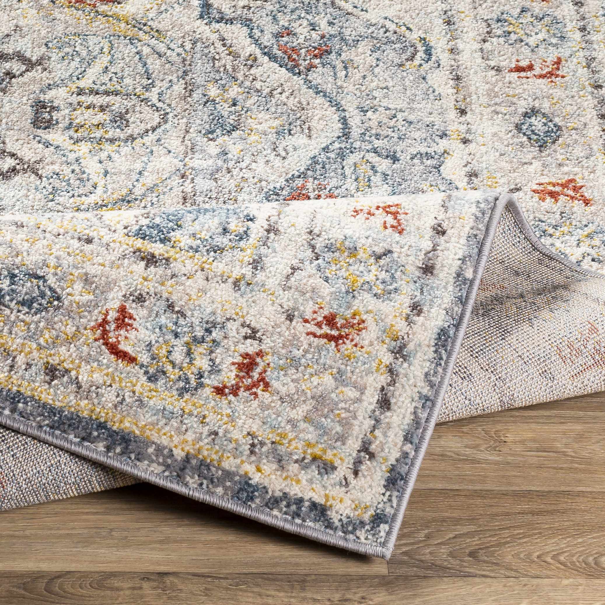 Folded section of Hanna Area Rug - Clearance, displaying material thickness and weave. Traditional Area Rug Backing  