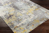 Close-up of the Hobson Abstract Area Rug showing its black, mustard, and gray contemporary design on a dark wood floor. Corner