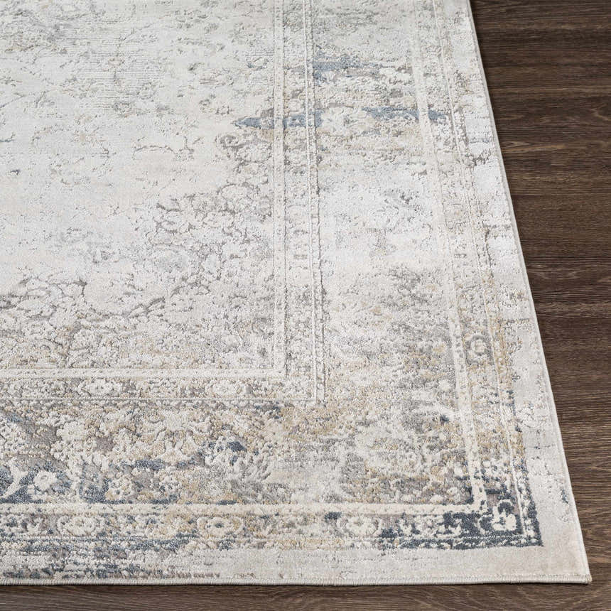 Close-up of the Holcombe Area Rug showing its cream, charcoal, and gray traditional pattern and machine-woven texture. Front