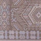 Close-up of the Honeydew Area Rug showing a hand-woven geometric pattern in cream, brown, light gray, and sky blue. Swatch