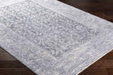 Close-up of Housatonic Area Rug in denim and white with a traditional oriental pattern on dark wood floors. Corner