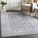 Living room scene with a denim Housatonic Area Rug, beige chair, and gold side table. Roomscene-Rectangle