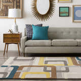 Living room scene with a gray sofa and the Harlech Area Rug in brown, blue, gray, ivory, and mustard. Roomscene-Rectangle