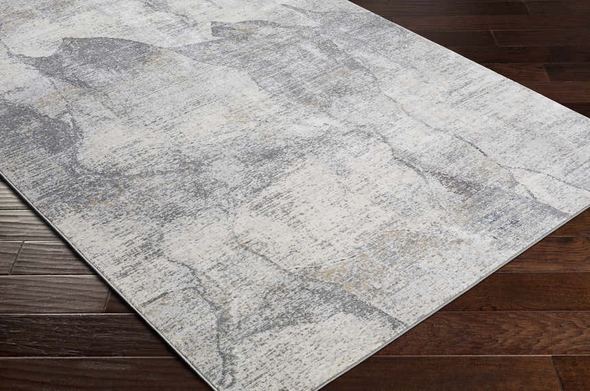 Close-up of the Hulme Gray Marble Luxe Rug showing its charcoal, gray, and beige marble-like pattern on dark wood floors. Corner
