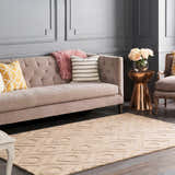 Living room scene with a tan Hundred Area Rug, gray walls, and a tufted sofa with decorative pillows. Roomscene-Rectangle