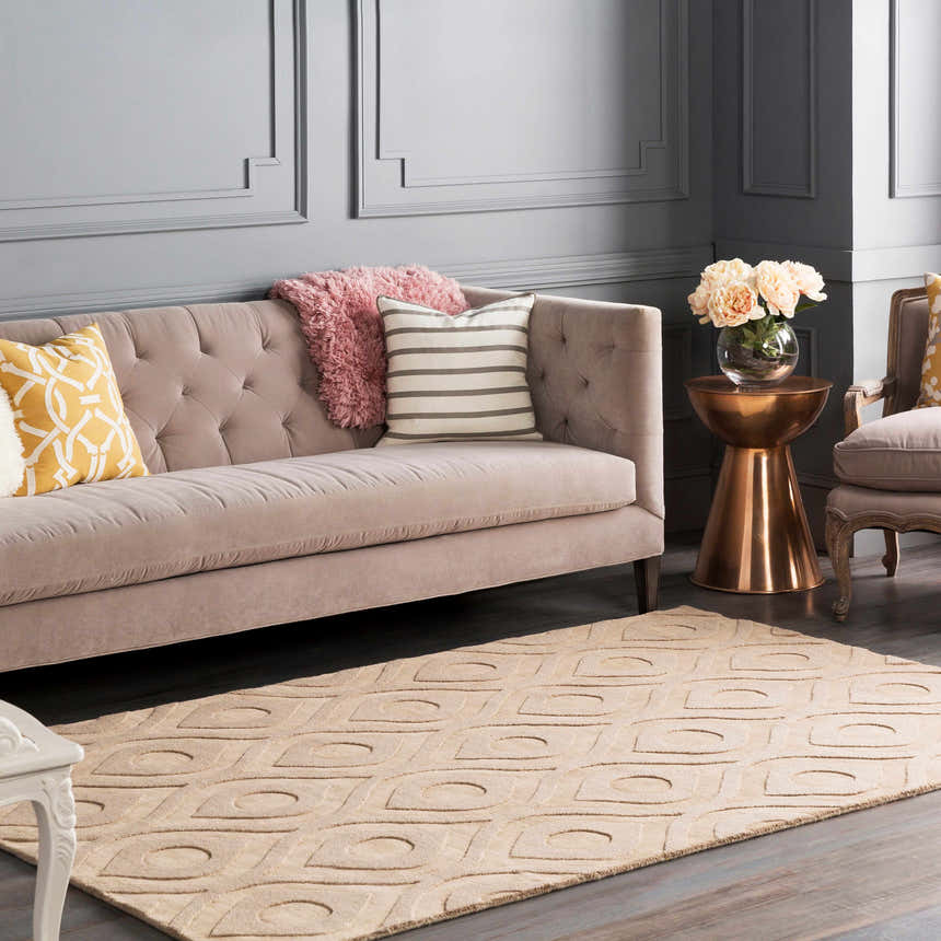 Living room scene with a tan Hundred Area Rug, gray walls, and a tufted sofa with decorative pillows. Roomscene-Rectangle