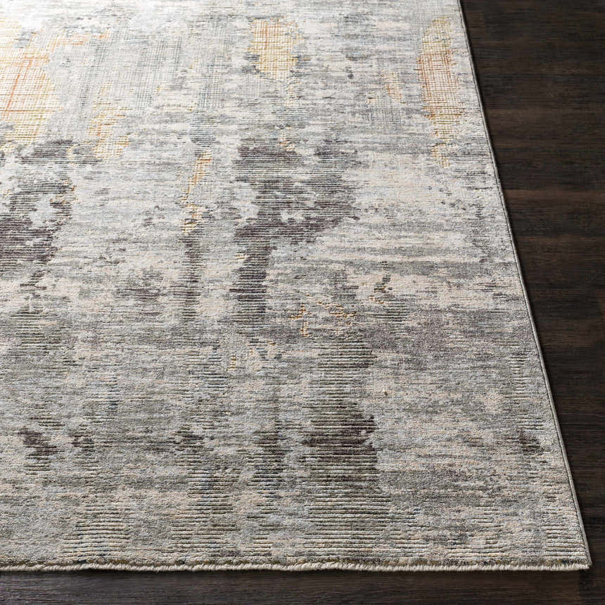 Close-up of the Hustontown Carved Statement Rug. Abstract pattern in blue, charcoal, sage, gray, and ivory on dark wood floor. Front