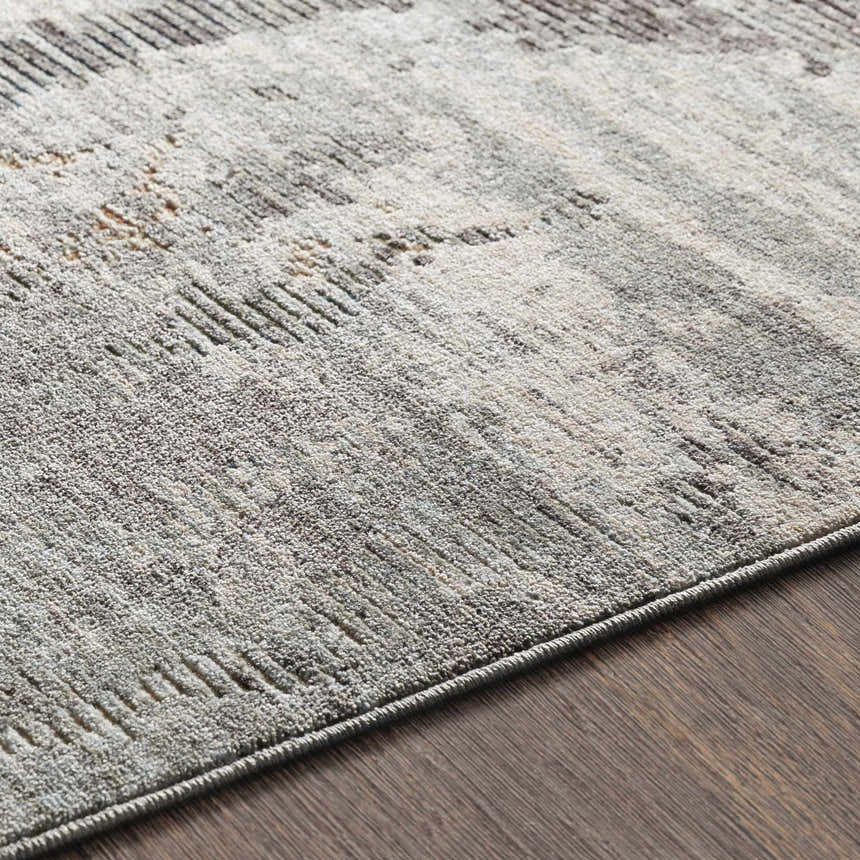 Close-up of the Hustontown Carved Statement Rug. Features a carved contemporary design in gray, ivory, and light olive hues. Texture