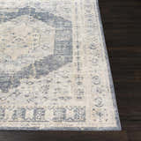 Close up of the traditional Indore Area Rug in black, charcoal, gray, off white, and tan on dark wood flooring. Front