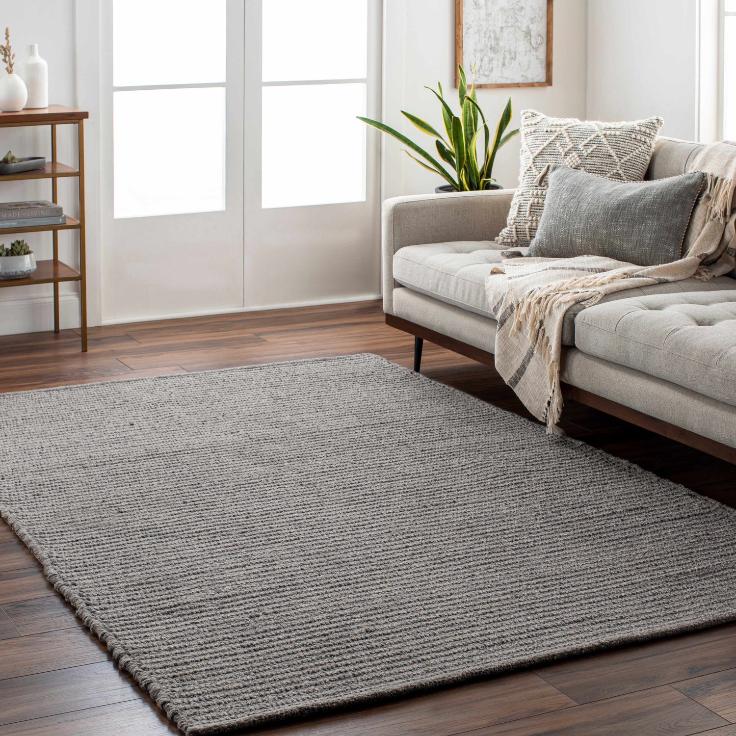 Living room scene with gray Innisfail Area Rug, beige sofa, wood floors, and neutral decor. Contemporary style. Roomscene-Rectangle
